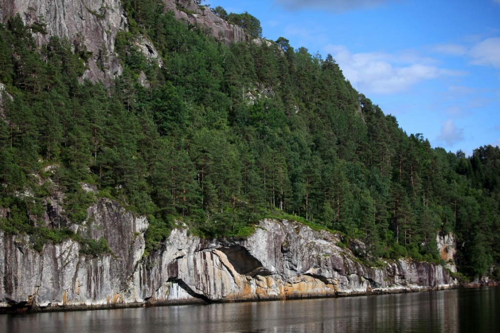 The granite cliffs plunge into the dark waters of Aurlandfjord.