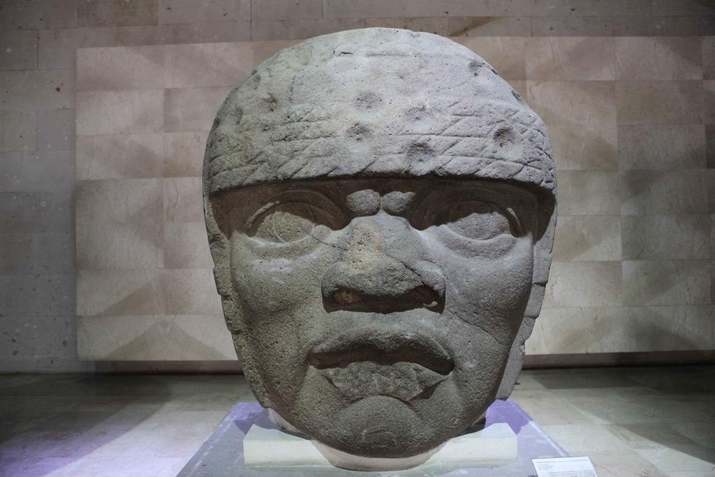 Colossal head no. 3. The facial features are very different from those of the other San Lorenzo heads. Some believe it could be a woman. The headdress is made up of 4 rows of strings with circular impacts that could be intentional mutilations from the Olmec period. 1200 BC ? 900 AD