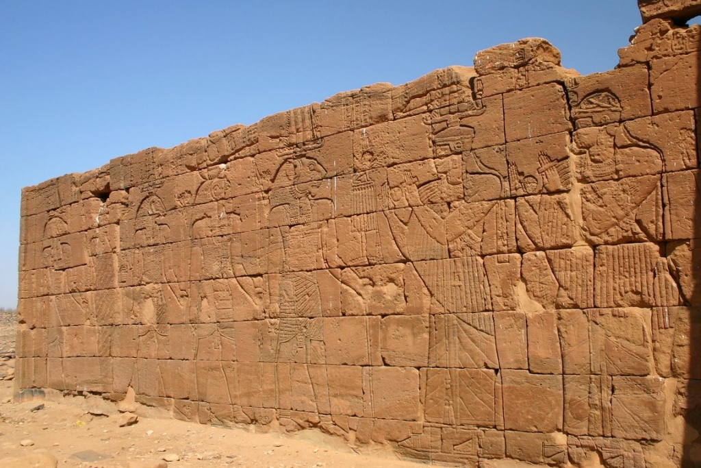 Moussawarat es-Soufra. Détail du relief du mur extérieur du temple d’Apédémak : le roi Arnékhamani et un prince, protégés par la déesse Isis, adorant le dieu lion Apédémak.