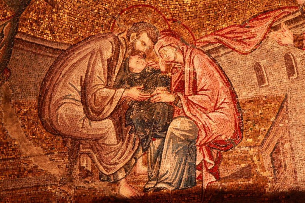 Chora. À l'ouest de la voûte d'une des parties du narthex intérieur, on trouve une mosaïque représentant l'adoration de Marie. Son père, Joachim, et sa mère, Anne, adorent leur fille Marie qu'ils tiennent entre leurs bras.