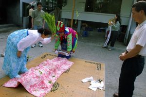 Corée du Sud. Rituel chaanique. L'assistante de la mudang se prépare à purifier une malade avec des tiges de riz.