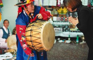 Corée du Sud. Rituel chamanique ou kut. La mudang appelle les esprits bienveillants avec son tambour.