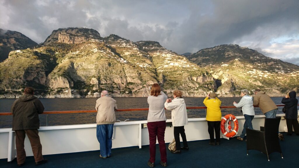 From the upper deck of the boat, you can look out over the Amalfi coast, bathed in gentle sunshine.