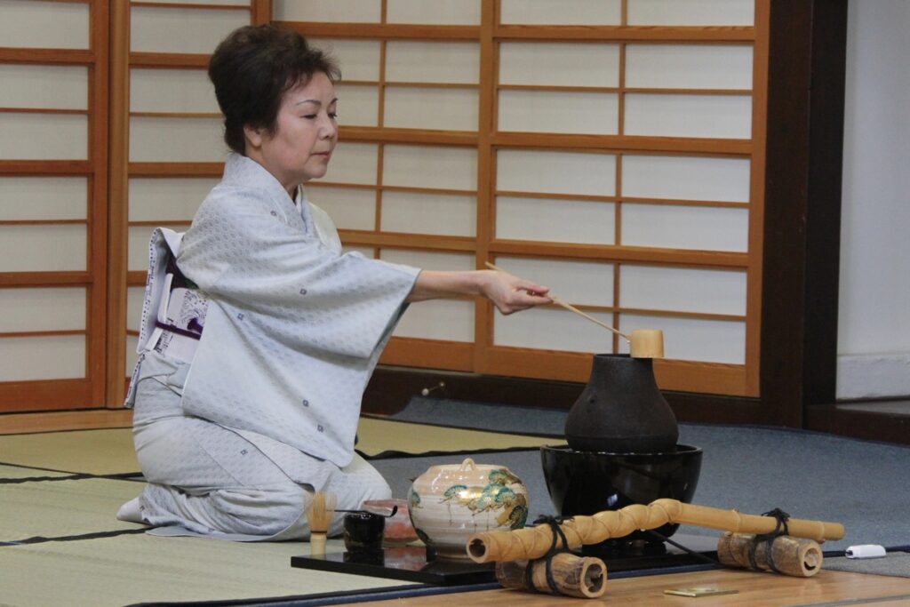 Japon. Cérémonie du thé. La maîtresse de thé puise  l'eau dans la bouilloire avec une louche en bambou.