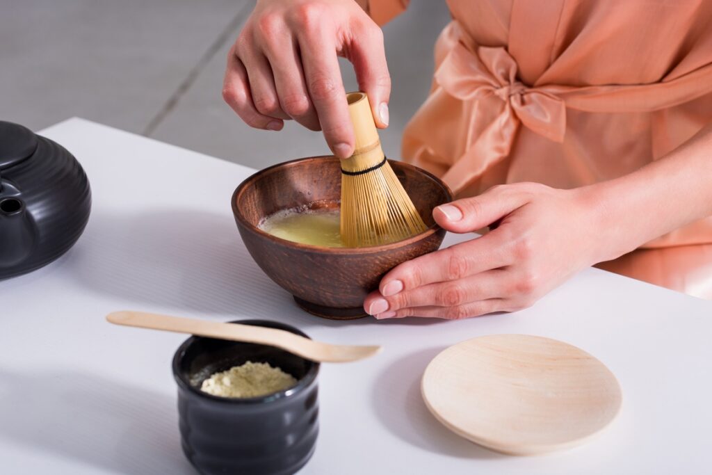 Japon. Cérémonie du thé. La maîtresse de thé Japon. Cérémonie du thé. La maîtresse de thé fouette rapidement le matcha avec le chasen.