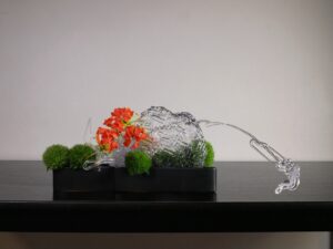 Ikebana. Ecole Sogetsu. Style Moribana. Polycarbonate, oeillets de poète et gloriosa.