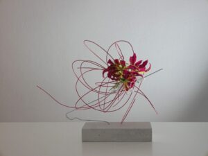 Ikebana. Ecole Sogetsu. Style libre. Socle en béton cellulaire, tige métallique, rotin et gloriosa.