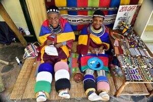South Africa. Young Ndebele girls from the village of Mpumalanga coming out of their initiation period. They wear coloured hoops around their legs or Isigolwani.