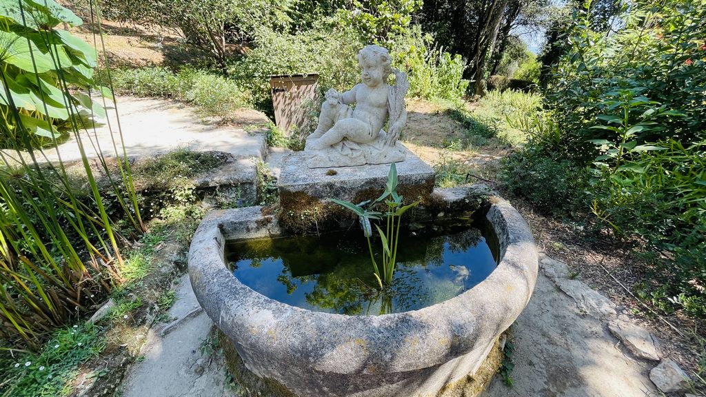 France. Menton. Serre de la Madone. A cherub watches over a pond full of frogs. 